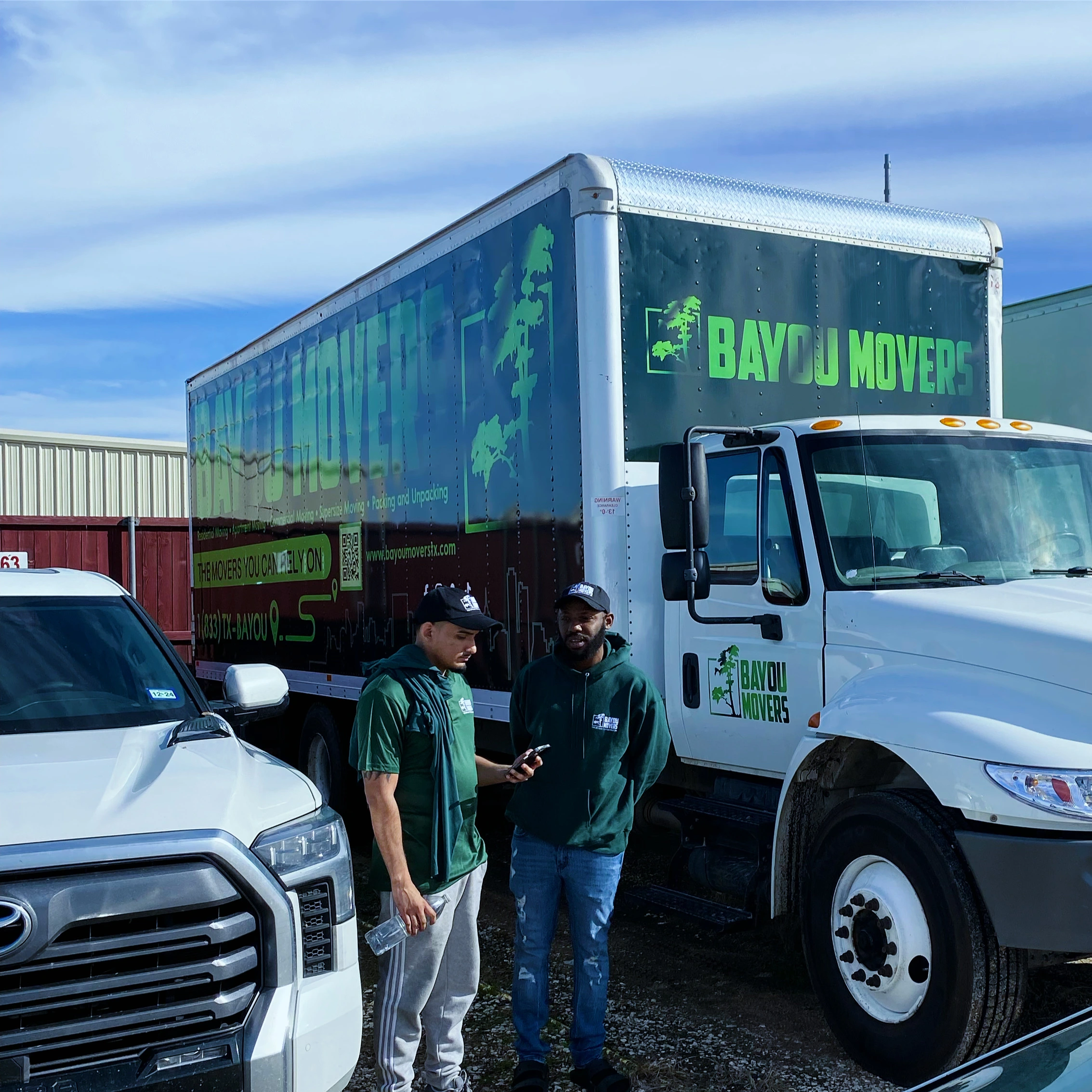 Two Bayou Movers crew members coordinating beside the truck
