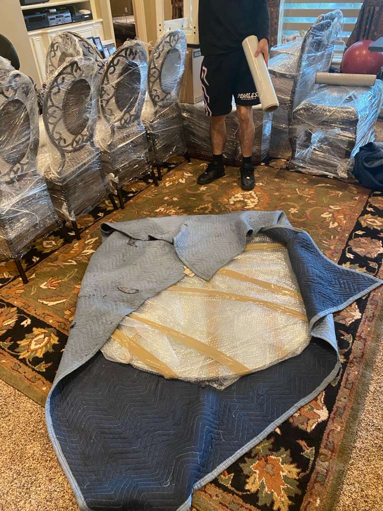 Dining chairs and tabletop wrapped for a Bayou Movers move in Cypress