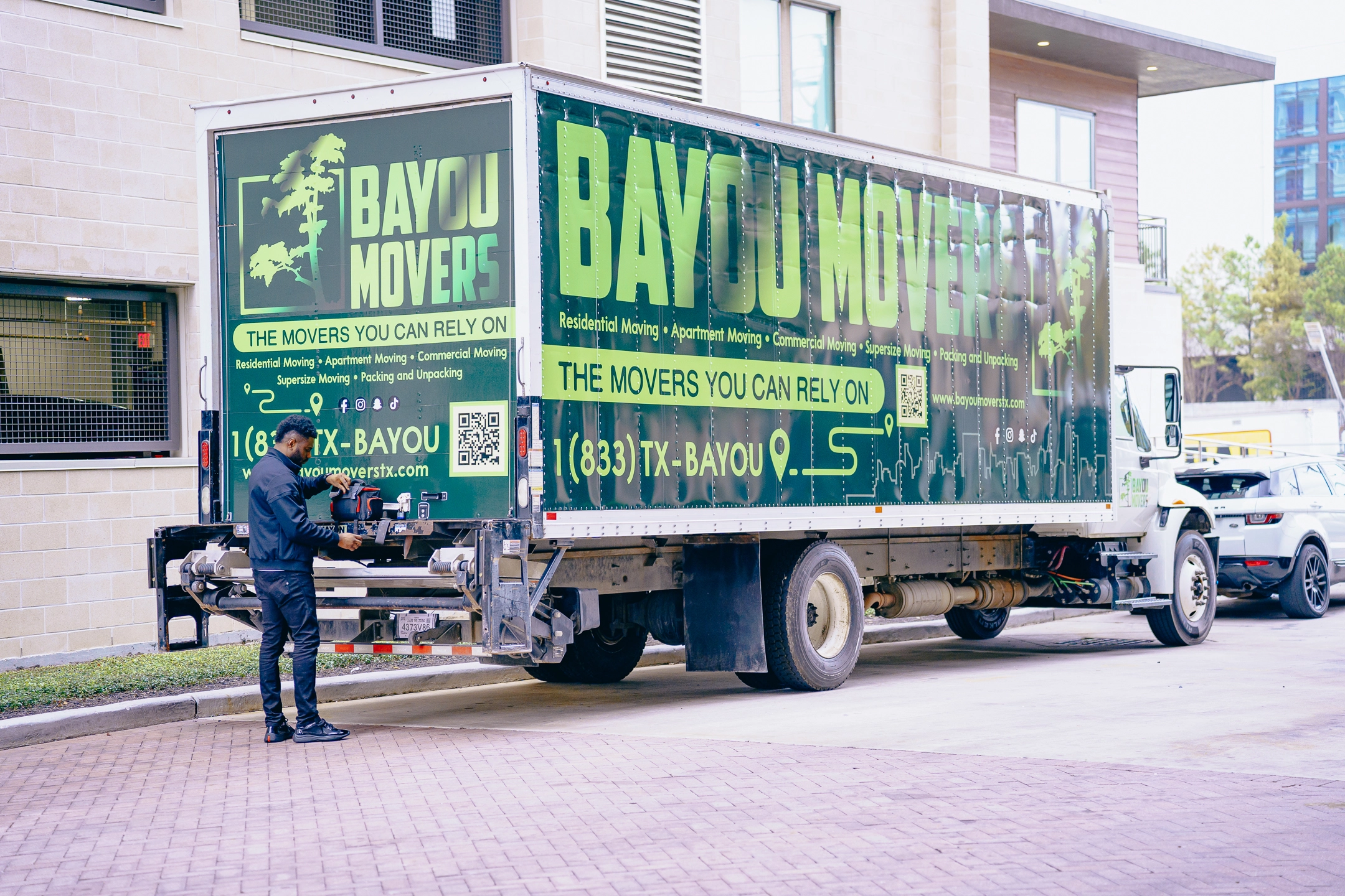 Bayou Movers truck staged beside a multi-story building