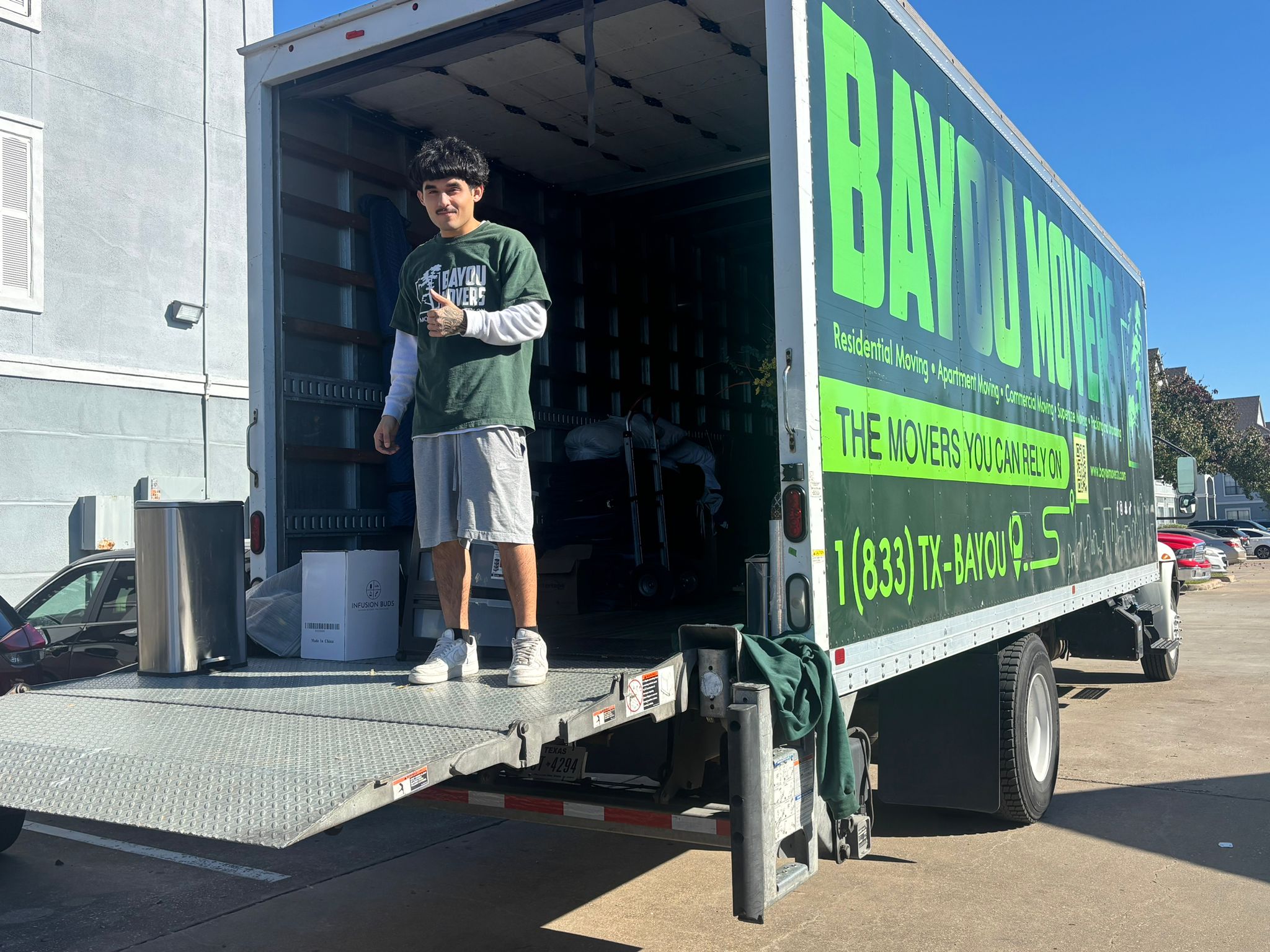 Bayou Movers crew member standing at the open truck liftgate