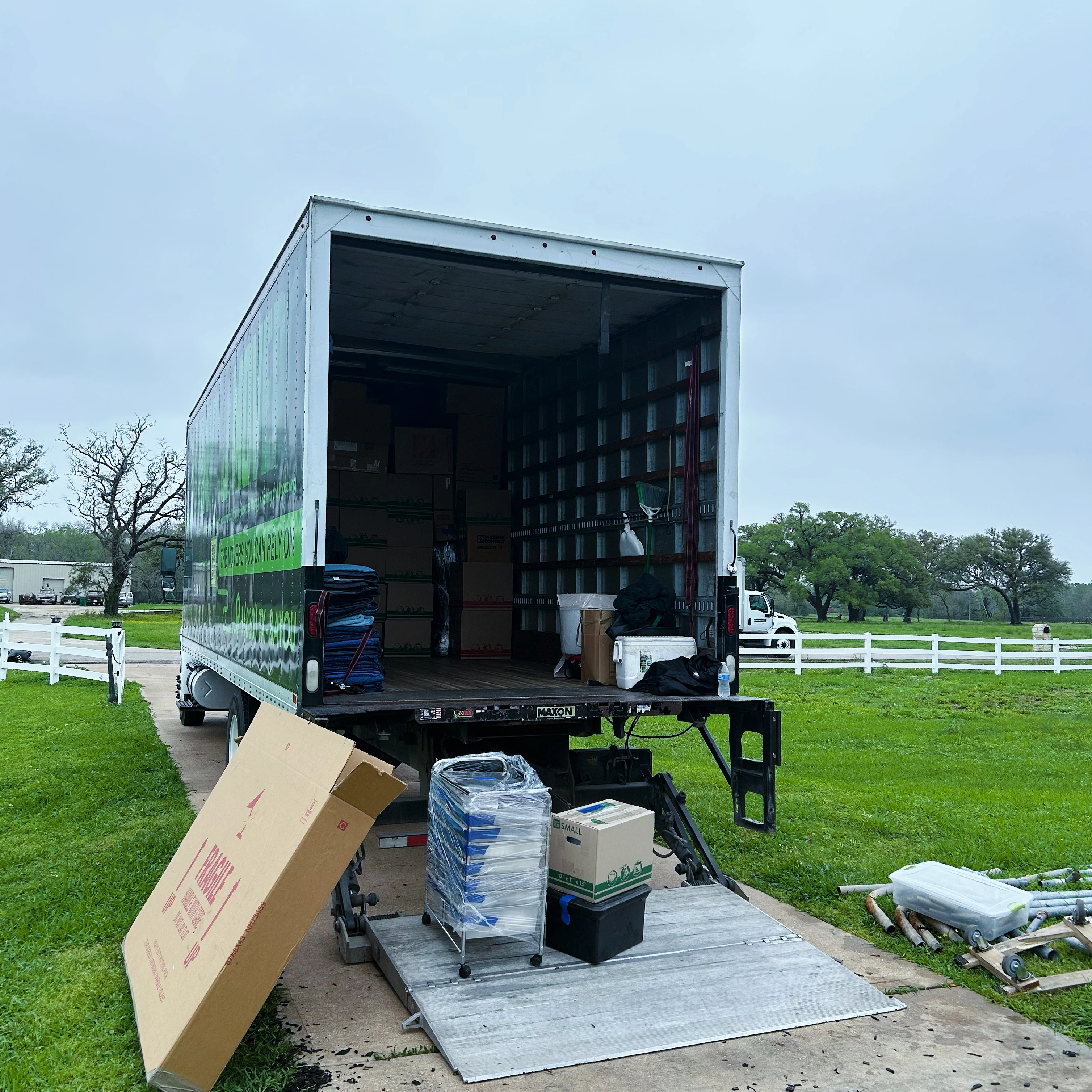 Packed boxes and moving supplies staged at a Bayou Movers truck liftgate