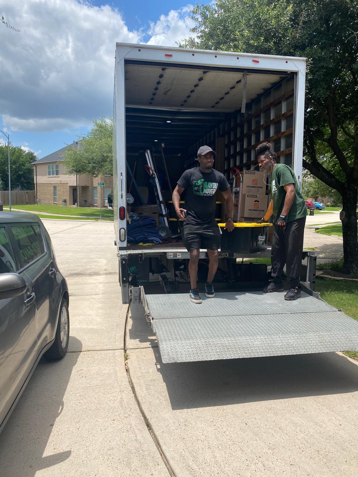 Two Bayou Movers crew members with the Bayou Movers truck in Houston